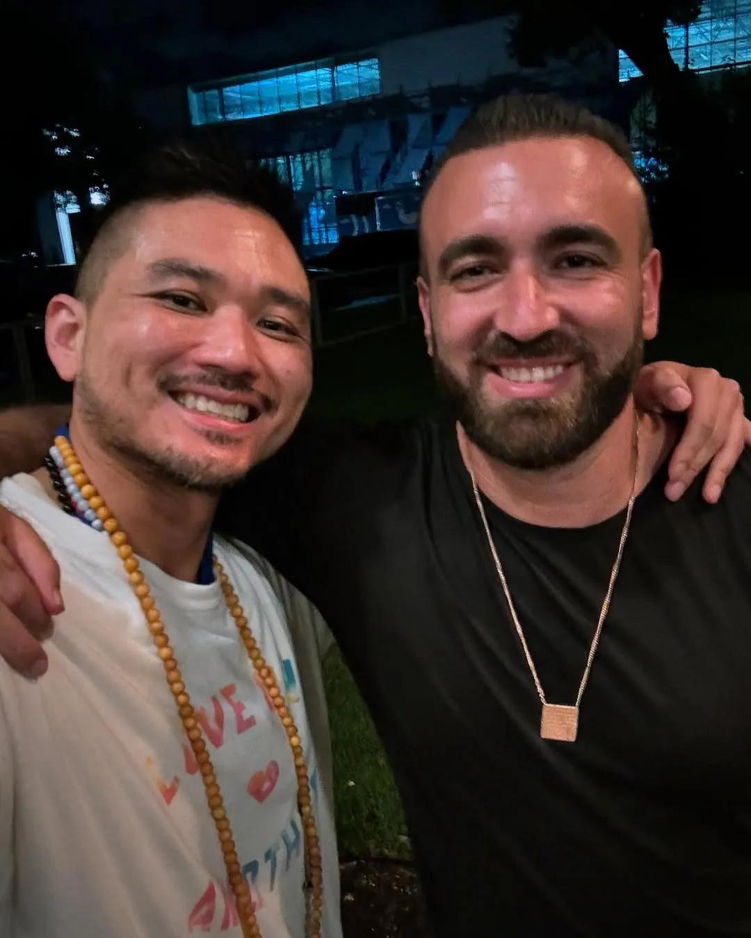 Patrick Chan with a man, both smiling, outdoors in the evening
